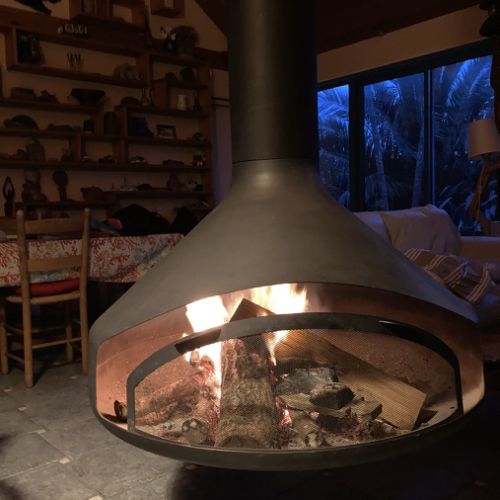 Suspended wood-burning fireplace in use